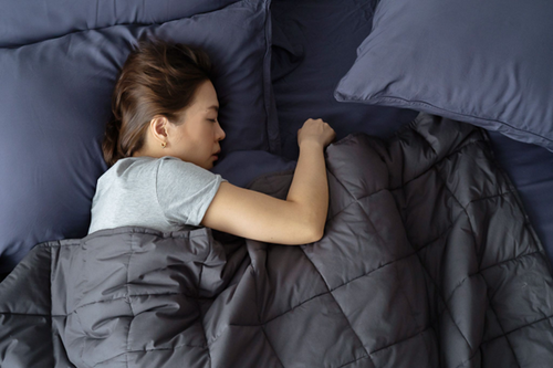 Woman sleeping under Weavve's weighted blanket
