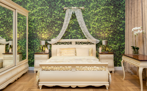 A serene bedroom with a classic king size bed, lush green backdrop, and soft, elegant touches for a calm, luxurious feel.
