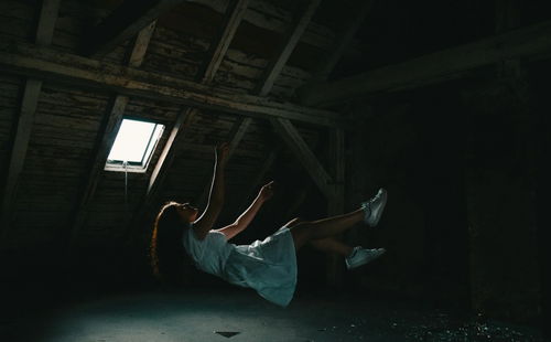 A woman in a white dress falling down