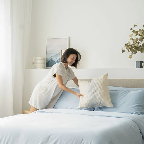 Woman fixing her bed