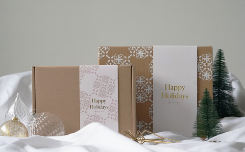 A close-up of a cardboard box beside a Christmas tree and festive decorations