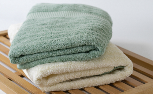 A close up of two towels on a wooden shelf