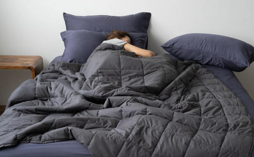 A woman sleeping with a weighted blanket