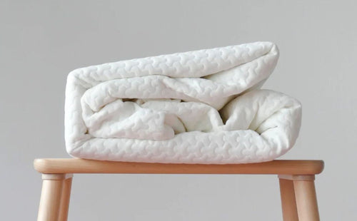 a white mattress protector on the chair