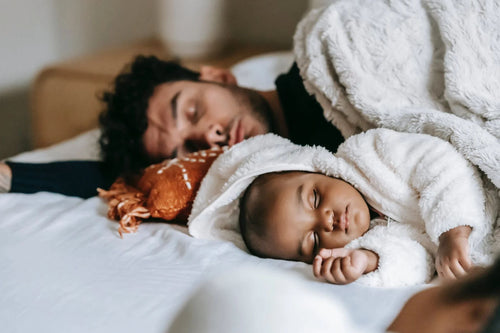 Dad and baby sleeping with weighted blanket and duvet