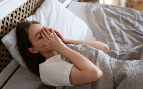 High angle anxious woman laying in bed