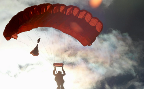 Person Riding on Red Parachute