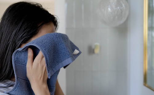 a girl using blue face towel