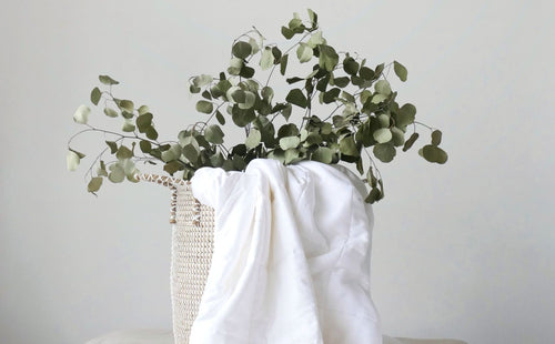 a mattress protector placed with eucalyptus basket