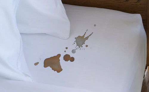 coffee stain on white bed sheet