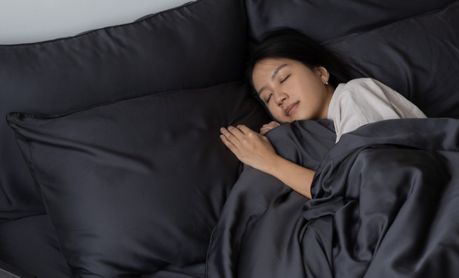 woman sleeping on weavve home's tencel sheets in slate grey colour