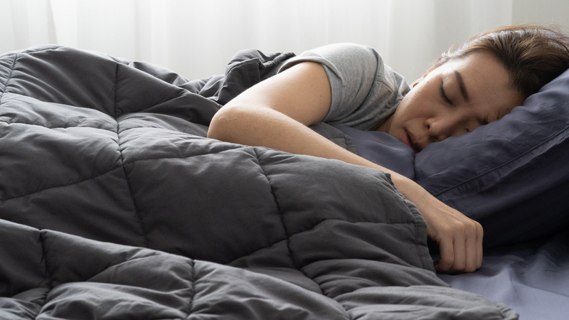 woman sleeping soundly under the weighted blankets