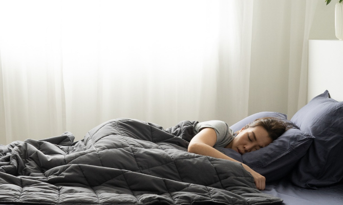 woman sleeping under weighted blanket and tencel bed sheets